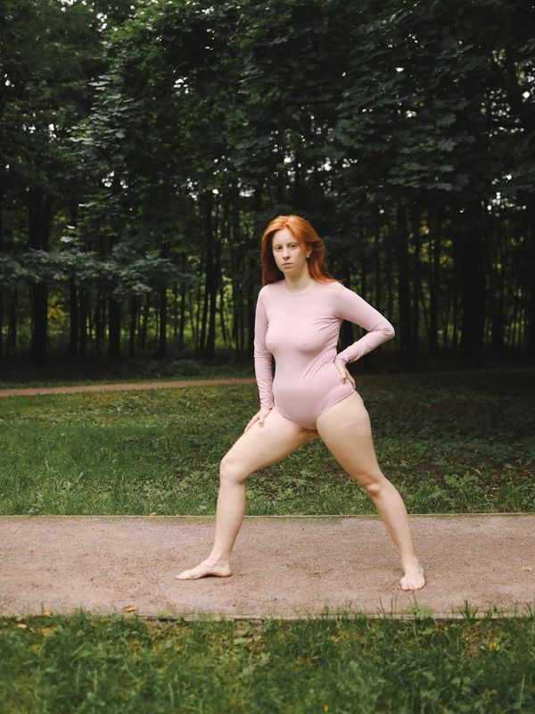 Person stretching outdoors during a sunrise, looking peaceful.
